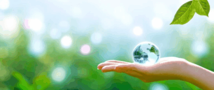 On a verdant nature setting, a woman delicately embraces the transparent globe of Earth in her hand