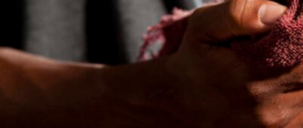 A man wiping his hand with a red cloth